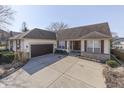 Inviting single-Gathering home showcasing a large driveway, attached garage, and decorative red shutters at 10324 Springridge Cir, Fishers, IN 46037
