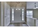 Bright and spacious foyer featuring a white front door with sidelights, wood-look floors, and neutral walls at 10324 Springridge Cir, Fishers, IN 46037