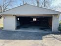 Spacious garage with open overhead door and gravel driveway at 1607 Elmhurst Dr, Indianapolis, IN 46219