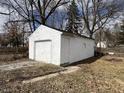 Detached one-car garage with white siding, a white garage door and single side door at 1632 W 17Th St, Anderson, IN 46016