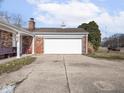 A garage with a white door is situated next to a brick house, providing convenient parking at 1840 Hibiscus Dr, Indianapolis, IN 46219