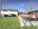 Charming split-level home with a well-maintained lawn, walkway and garden at 3736 W South Wood Lake Dr, Columbus, IN 47201