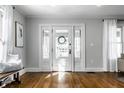 Bright foyer featuring hardwood floors, a bench seat, and a beautiful front door at 4055 Broadway St, Indianapolis, IN 46205