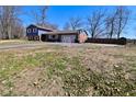 A view of the home from the backyard and driveway with a full yard and beautiful trees at 425 Conduitt Dr, Mooresville, IN 46158