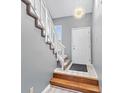 Bright entryway features a staircase with carpet runner, white door, and modern light fixture at 4647 Framington Ct, Indianapolis, IN 46254
