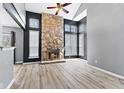 Open living room with stone fireplace, ceiling fan, and views of the staircase and kitchen at 4647 Framington Ct, Indianapolis, IN 46254