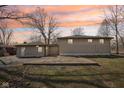 View of the home's rear exterior, showcasing a concrete patio and detached garage with a well-maintained backyard at 4709 S County Road 500 E, Plainfield, IN 46168