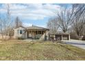 Quaint home with a cozy front porch and a detached two-car garage, surrounded by mature trees in a serene setting at 4709 S County Road 500 E, Plainfield, IN 46168