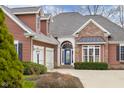 Close-up of the home's front exterior showcasing the brick and wood facade, two-car garage, and landscaped yard at 4965 N 500 W, Columbus, IN 47201