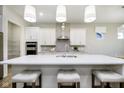 Modern kitchen showcasing an island with seating, stainless steel appliances, and stylish pendant lighting at 5647 Stetson Dr, Whitestown, IN 46052