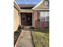 A welcoming covered entrance features a charming brick facade with space for planting flowers and greenery at 5832 Cabot Dr, Indianapolis, IN 46221