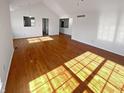 Spacious living room featuring gleaming hardwood floors and lots of natural light from multiple windows at 6232 Behner Xing, Indianapolis, IN 46250