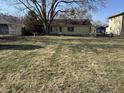 Expansive backyard with mature trees and landscaping surrounding the house, creating a peaceful outdoor space at 654 Holiday Dr, Fortville, IN 46040