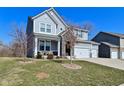 Charming two-story home with a manicured lawn, stone accents, and a three car garage at 655 Bracknell Dr, Avon, IN 46123