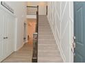 Elegant foyer with a carpeted staircase, wood railing, and view of the second floor landing at 655 Bracknell Dr, Avon, IN 46123