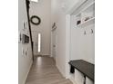 Hallway with coat rack and storage bench leading to the front door and staircase at 655 Bracknell Dr, Avon, IN 46123