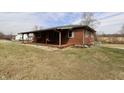 Well-maintained single-story brick home featuring a wide covered front porch and manicured landscaping at 6900 W Georgetown Rd, Columbus, IN 47201