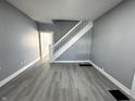 Bright living room featuring modern gray walls, stylish floors, and a staircase at 745 W 25Th St, Indianapolis, IN 46208
