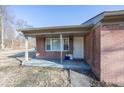 Charming brick home entrance featuring a cozy covered porch and a classic front door at 960 W 52Nd St, Indianapolis, IN 46208