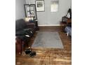 Spacious living room area with hardwood floors, a gray rug, a leather couch, and natural light at 960 W 52Nd St, Indianapolis, IN 46208