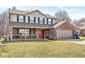 Charming two-story home featuring a brick and siding exterior with a welcoming front porch and two-car garage at 10111 Ironway Dr, Indianapolis, IN 46239