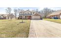 Charming two-story home featuring a brick and siding exterior with a welcoming front porch and two-car garage at 10111 Ironway Dr, Indianapolis, IN 46239