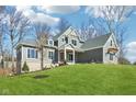 Well-manicured two-story home with gray siding, gray shingles, and a lush lawn at 10756 Dartmoor Way, Zionsville, IN 46077
