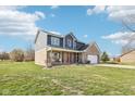 Charming two-story home features a brick and blue exterior, spacious front yard, and long driveway at 12121 N Berling Dr, Mooresville, IN 46158