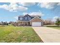 Charming two-story home features a brick and blue exterior, spacious front yard, and covered front porch at 12121 N Berling Dr, Mooresville, IN 46158