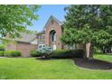 Traditional brick home with mature trees and landscaping, offering a serene and inviting curb appeal at 12307 Pebblepointe Pass, Carmel, IN 46033