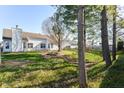 Large backyard featuring mature trees, a fire pit, and a white picket fence at 245 Suncrest Dr, Greenwood, IN 46143