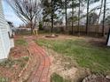 View of the backyard including a brick patio with a fire pit and grassy area at 245 Suncrest Dr, Greenwood, IN 46143