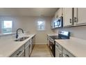 Modern kitchen with stainless steel appliances, white cabinetry, quartz countertops, and wood-look flooring at 2617 N Temple Ave, Indianapolis, IN 46218