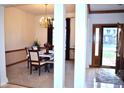 Inviting dining room with elegant chandelier, carpeted floor, and a clear view of the front door at 37 Trotters Run, Brownsburg, IN 46112