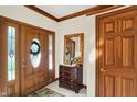 Inviting foyer with wood accents, tile flooring, and a decorative mirror on the accent chest at 37 Trotters Run, Brownsburg, IN 46112