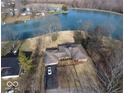 Aerial shot of brick home, long driveway and lake, with a car in the driveway at 3752 W North Wood Lake Dr, Columbus, IN 47201