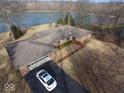 Aerial view of brick home with attached garage, long driveway, and lake in the background at 3752 W North Wood Lake Dr, Columbus, IN 47201