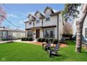 Inviting two-story home featuring a lush green lawn and Adirondack chairs for enjoying the outdoors at 5032 N Illinois St, Indianapolis, IN 46208