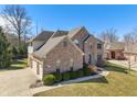 Gorgeous brick home featuring an attached garage and well-manicured lawn and landscaping at 5517 Westbourne Ct, Greenwood, IN 46143