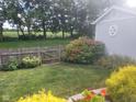 A well-maintained backyard featuring a shed, lush greenery, privacy fence, and beautiful flower beds at 5757 Pebblebrooke Rd, Whitestown, IN 46075