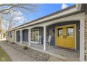 Welcoming front porch with arched supports, rocking chairs, and a cheerful yellow door at 6201 S Carroll Rd, Indianapolis, IN 46259