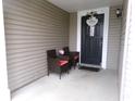 Inviting front porch with wicker seating and a decorative 'Bless This Home' door decor at 6651 Sonesta Dr, Indianapolis, IN 46217