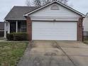 Charming single-story home with attached two-car garage, front entryway, and partial brick facade at 7128 Moon Ct, Indianapolis, IN 46241