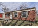Low angle view of the home's front exterior with a classic red brick exterior at 7602 E 34Th Pl, Indianapolis, IN 46226
