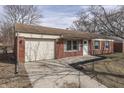 View of the home's front exterior featuring a one car garage and well-lit front entrance at 7602 E 34Th Pl, Indianapolis, IN 46226