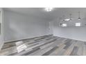Bright living room featuring wood-look floors and modern lighting fixtures, freshly painted at 7602 E 34Th Pl, Indianapolis, IN 46226