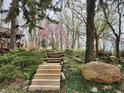 Landscaped yard with steps leading up to the home, surrounded by lush greenery and trees at 10960 Marlin Rd, Indianapolis, IN 46239