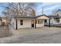 Side view of a beautifully renovated house with white siding, a black roof, and manicured landscaping at 1209 N Centennial St, Indianapolis, IN 46222