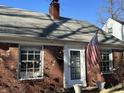 Charming brick home featuring a classic design, a well-maintained roof, and an American flag at 1230 Kessler Blvd E Dr, Indianapolis, IN 46220