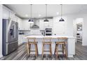 Bright kitchen with a large island, stainless steel appliances, pendant lighting, and white cabinets at 14859 Amber Light Dr, Westfield, IN 46074